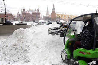 Moscow, russia, december 21, 2009, man operates an avant 220 skid steer loader to clear snow away from the front of the national moscow hotel, manezhnaya square, central moscow.