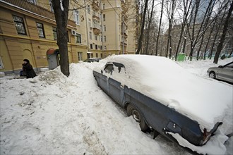 Moscow, russia, february 4, 2010, abandoned car buried in snow outside a building in central moscow, russia is launching a cash-for-bangers scheme in march 2010 to encourage motorists to scrap their u...