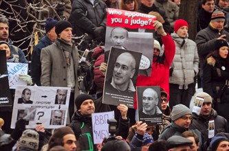 Moscow, russia, december 27, 2010, supporters of mikhail khodorkovsky hold up his portraits during a rally outside the khamovniki district court, the court is expected to issue its ruling on the secon...