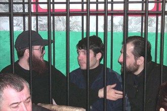 Makhachkala, dagestan, russia, december 5, 2001, salman raduyev (left) and his supporters on terrorism charges pictured on wednesday behind the bars at the courtroom, after witnesses and survivors of ...