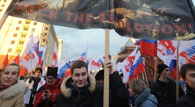 Moscow, russia, december 12, 2011, young demonstrators carry a placard reading fuck the revolution! during a rally staged by pro-kremlin youth groups in central moscow, the event took place two days a...