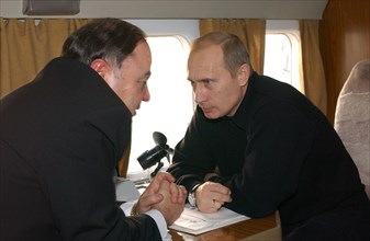 Russia, november 5, president vladimir putin (r) and adygeya head khazret sovmen talking on board a plane on tuesday, when the russian head of state inspected the reconstruction of housing in the floo...