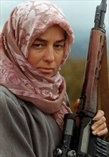 Dagestan, russia, october 22, 1999, director of the dylymsky women's medrese fazilyat kinailat magomedova poses to the camera with a sniper rifle in her arms, following the intrusion of the chechen ga...