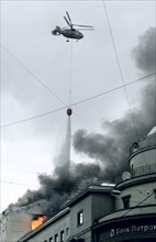 A firefighting helicopter drops water on a building engulfed by flames in petrovka street, central moscow, russia, august 26, 2006.