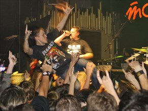 Youth raise their hands as they listen to music at 'tochka' club, the venue of the 'punks in city x' festival, august 26, 2006.