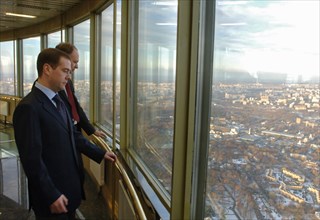 Head of russia's federal press and mass communications agency mikhail seslavinsky and russian first deputy prime minister dmitry medvedev, foreground, look at the city from ostankino tv tower observat...