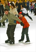 People skate on the ice rink in krylatskoye ice palace, moscow, russia, january 2007.