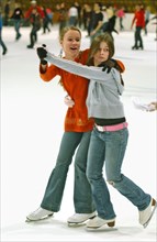 Teenagers skate on the ice rink in krylatskoye ice palace, moscow, russia, january 2007.