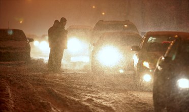 Moscow, russia, february 13, 2007, cars driving along a street with their headlights on in snowy blizzard.