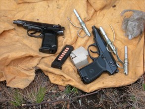 Two izh baikal guns with gun silencers, gun cartridges, grenade fuses found in a weapons and ammunition cache uncovered in chita region, may 25, 2007.