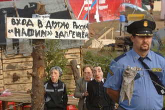 Sign reading 'entrance to the other russia for our people forbidden', a security guard and a puppet of tycoon boris berezovsky, third from left, seen at the summer camp of the pro-putin nashi (our peo...