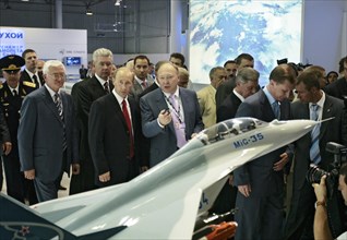 Russian president vladimir putin, head of the united aircraft building corporation, alexei fedorov, l-r, foreground, view a model of mikoyan mig-35 fighter at the 8th international aviation & space sa...