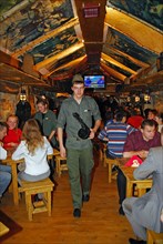 Waiter (c) wearing fatigues, with an assault rifle, at kryivka, a new cafe with the decor of a upa (ukrainian insurgent army) bunker, in the city of lvov (lviv), western ukraine, october 2007.