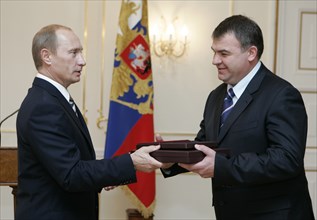 President of russia vladimir putin (l) hands over the awards, posthumously conferred on the soviet spy george koval, to defence minister anatoly serdyukov to be stored at the museum of russia's main i...