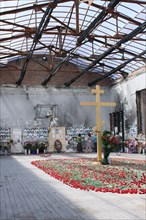 North ossetia, russia, september 3, 2008, christian orthodox cross erected in the center of the devastated former school no1 gym, the scene of the 2004 beslan school siege, mourners bring red carnatio...