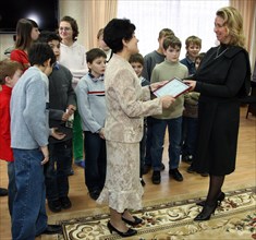 St petersburg, russia, november 4, 2008, svetlana medvedeva (r) hands over the $19000 (500 000 rubles) grant to school principal lyudmila borovikova (c) during a visit of russia's first lady to an orp...