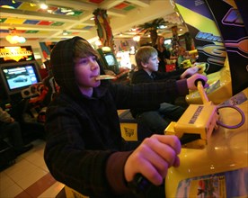 Boys enjoying themselves at a video game arcade in the fantasy park family leisure center, moscow, russia, january 2009.