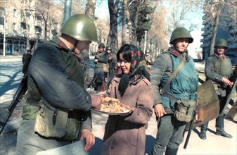 A woman offers a treat to soldiers in dushanbe, a state of emergency was declared in dushanbe after a violent unauthorized rally, policemen and servicemen were deployed to keep order, tajikistan, febr...