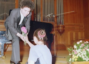 Russian pianist yevgeny kisin accepts a flower from one of his the admirers after an 1997 piano recital.