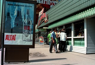 Moscow, russia, 2000, a poster (left) advertising a vodka distilled in the altai territory, and (right) a kiosk selling light alcoholic drinks and beer.