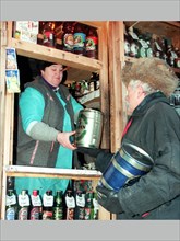A man buying mini-kegs of beer at a kiosk in russia, 2002.