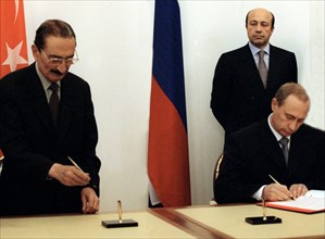 Russian prime minister vladimir putin and his turkish counterpart bulent ecevit signing agreements on scientific, technical, and military co-operation while russian foreign minister igor ivanov looks ...