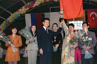 Elista, chess city, kalmykia, october 13, 1998, sportswomen of the chinese national chess team demonstrate the olympic cup, handed to them by the fide president kirsan ilyumzhinov /centre/, in elista,...