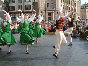 Folk dance groups perform at the traditional autumn fair in old riga.