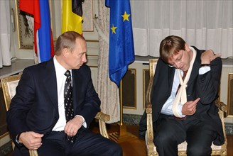 Brussels,belgium, november 12 2002: belgian prime minister guy verhofstadt (r) tells russian president vladimir putin about his broken arm at their bilateral working meeting on monday upon completion ...