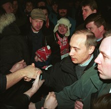 Acting president and prime minister vladimir putin (2nd from right) being greeted by football fans at moscow's luzhniki stadium on saturday when he came to watch a match between spartak moscow and ala...