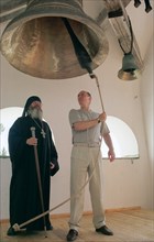 Russia, august 21 2001, president vladimir putin (right) ringing the bell during his visit to the spaso-preobrazhensky (savior's transfiguration) monastery at the vallam island, accompanied by archima...