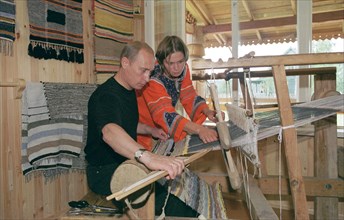 karelia, russia, august 21 2001, president vladimir putin tries his hand at weaving at the ancient loom, while visiting the ethnographic village of verkhniye mondrogi on his way to the kizhi island.
