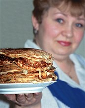 Yekaterinburg, russia, 3/13/02: yekaterina zasada, a resident of yekaterinburg, showing off a pile of bliny (pancakes) she has cooked for maslenitsa (shrovetide), which is celebrated this week, tradit...