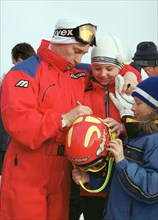 Irkutsk region, russia, march 27 2002, president vladimir putin giving autographs to little skiers while spending his brief vacation at the baikalskaya ski base in irkutsk region.