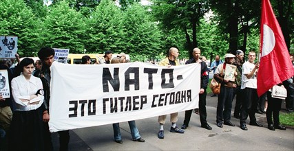Riga, latvia, june 17, 2002: the protestors hold a banner reading 'nato is the hitler of our time', an authorized picket of latvian national bolsheviks protesting against latvia's joining nato, was he...
