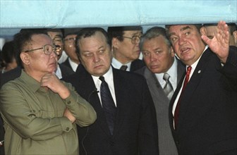 North korean leader kim jong-il (l) listens to explanations of the president of the jsc 'vladivostok commercial seaport' mikhail robkanov (r), at the port on friday, 8/23/02, a special awning was erec...