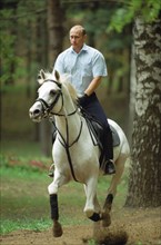 Russian president vladimir putin horse-riding in his residence in  novo-ogaryovo on july 26, 2002.