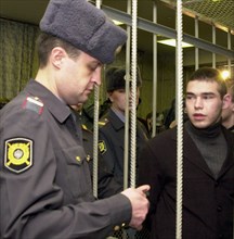 Moscow, russia, november 20 2002: one of the accused (right) under guard of policemen at the moscow city court, where verdicts were handed down today, wednesday, to five persons charged with participa...