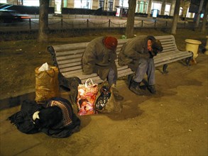 Moscow, russia, november 27 2002: some homeless people pictured on a bench in downtown moscow suffering from cold winter weather at night ,(photo andrey kuzin).