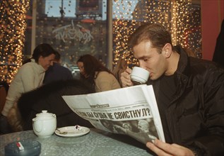 A young man drinks tea in a fashionable and expensive new restuarant in moscow, russia, 2003.