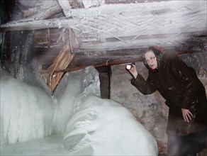Nizhni novgorod, russia, january 14 2003: valentina kotyashova pictured examining the basement of her house after heavy frosts that paralyzed the water and heat supply pipes, people in 176 old houses ...