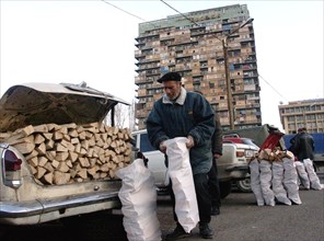 Tibilisi,georgia, january 15 2003: picture shows the selling of logs in downtown tiblisi near the iveria hotel , an unusually cold winter in georgia forced the residents of the city to seek means for ...