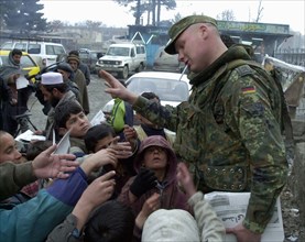 Kabul, afghanistan 2/03, afghani children with a soldier of the international peacekeeping force.