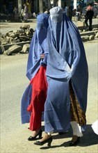 Afghanistan, march, 7 2003, afghani women wearing burkas, traditional capes with veils hiding the person, try to look attractively: from under the cape clothes corresponding to a local fashion and foo...
