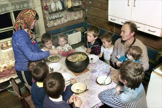 Chuvashia, siberia, russia, october 25 2003, chuvash family living in poverty, mother valentina pours soup for father leonid and their children, there are ten boys in the family, the eldest is 13 year...