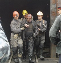 Rostov region, russia, october 25, 2003, rescuers help one of the miners evacuated from a shaft of the zapadnaya coalmine, rostov district, southern russia.