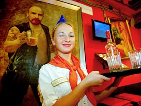 Waitress serving beer at a popular st, petersburg restaurant ilyich's call (lenin's mating call) with theme of soviet era nostalgia, waitress is dressed in the uniform of the young pioneers (soviet gi...