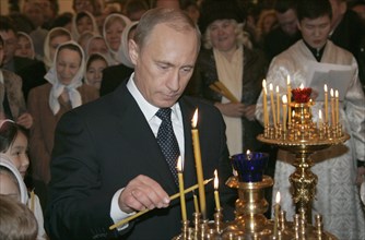 Russian president vladimir putin lights a candle during russian orthodox christmas celebrations on the eve of the holiday friday in a cathedral in the siberian city of yakutsk, orthodox christians use...