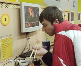 A young man eating sushi at the cafemax internet centre in pyatnitskaya, moscow, russia.