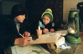 Russia, maritime terr, 12/2000, heating crisis: kids doing their homework in town of artem.